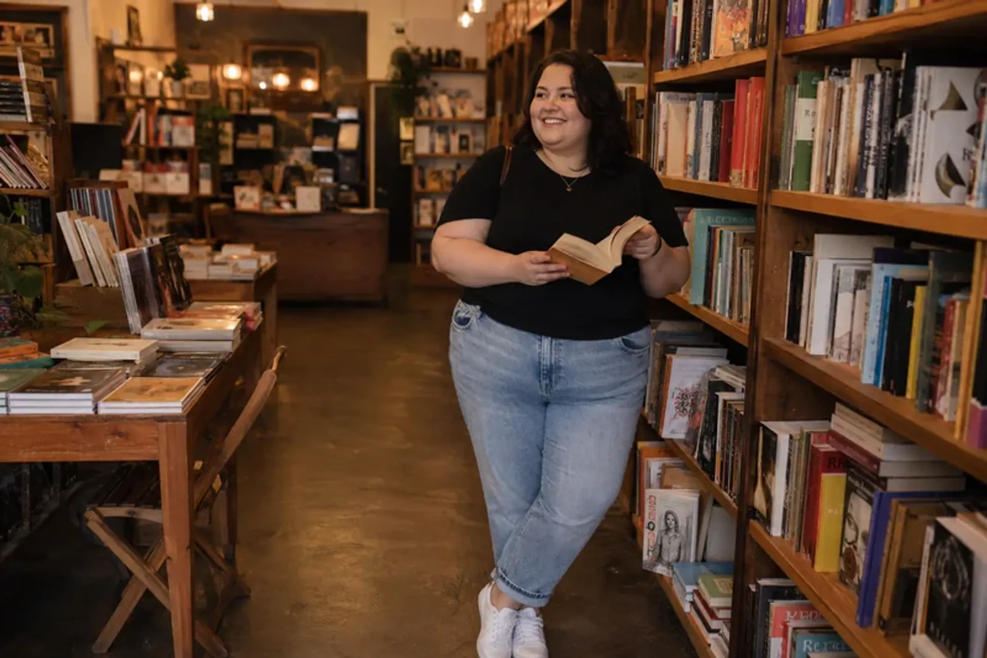 Plus-size woman browsing a bookstore in a warm potential-date lifestyle photo