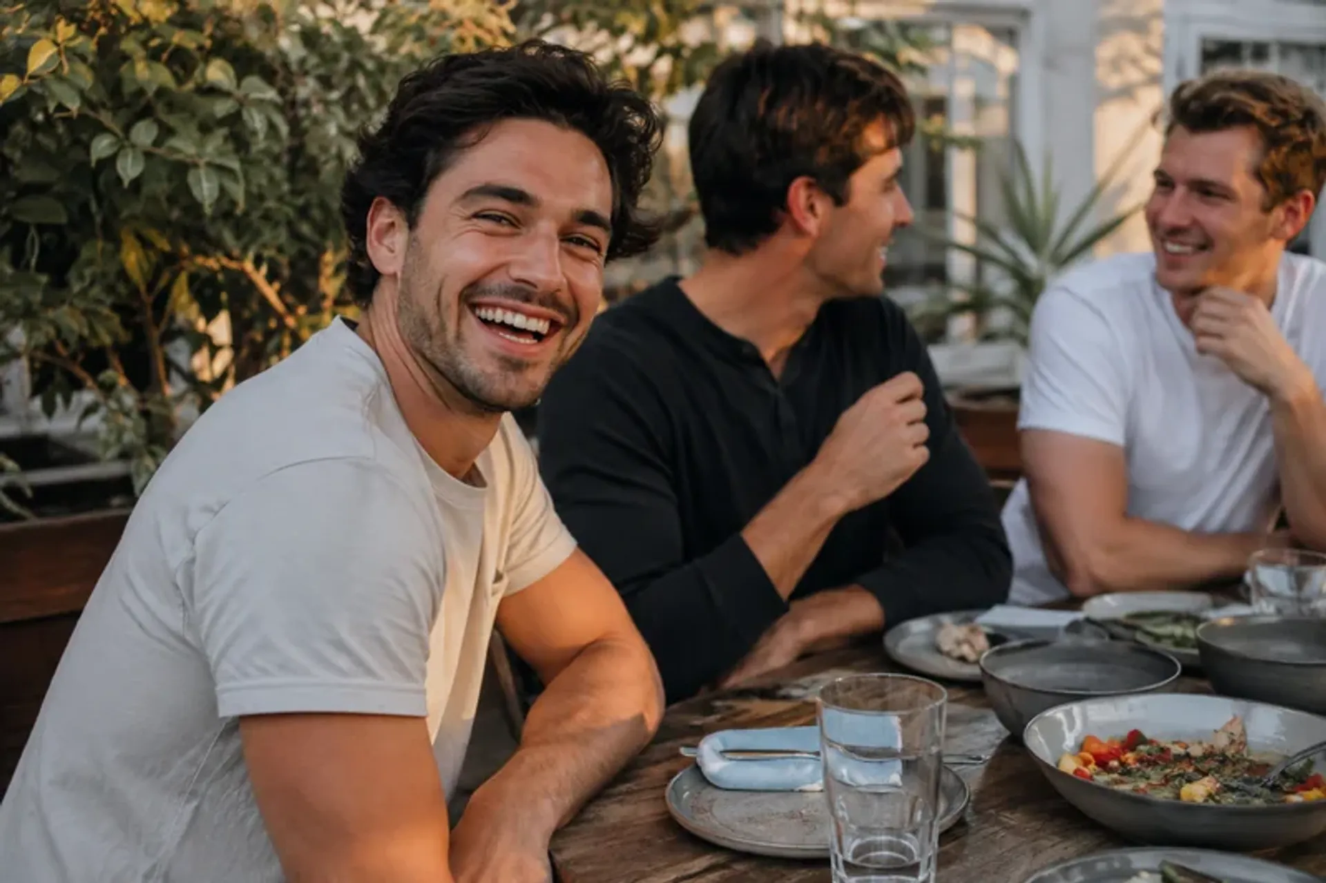 Man clearly identifiable with two friends in a social candid dating profile photo