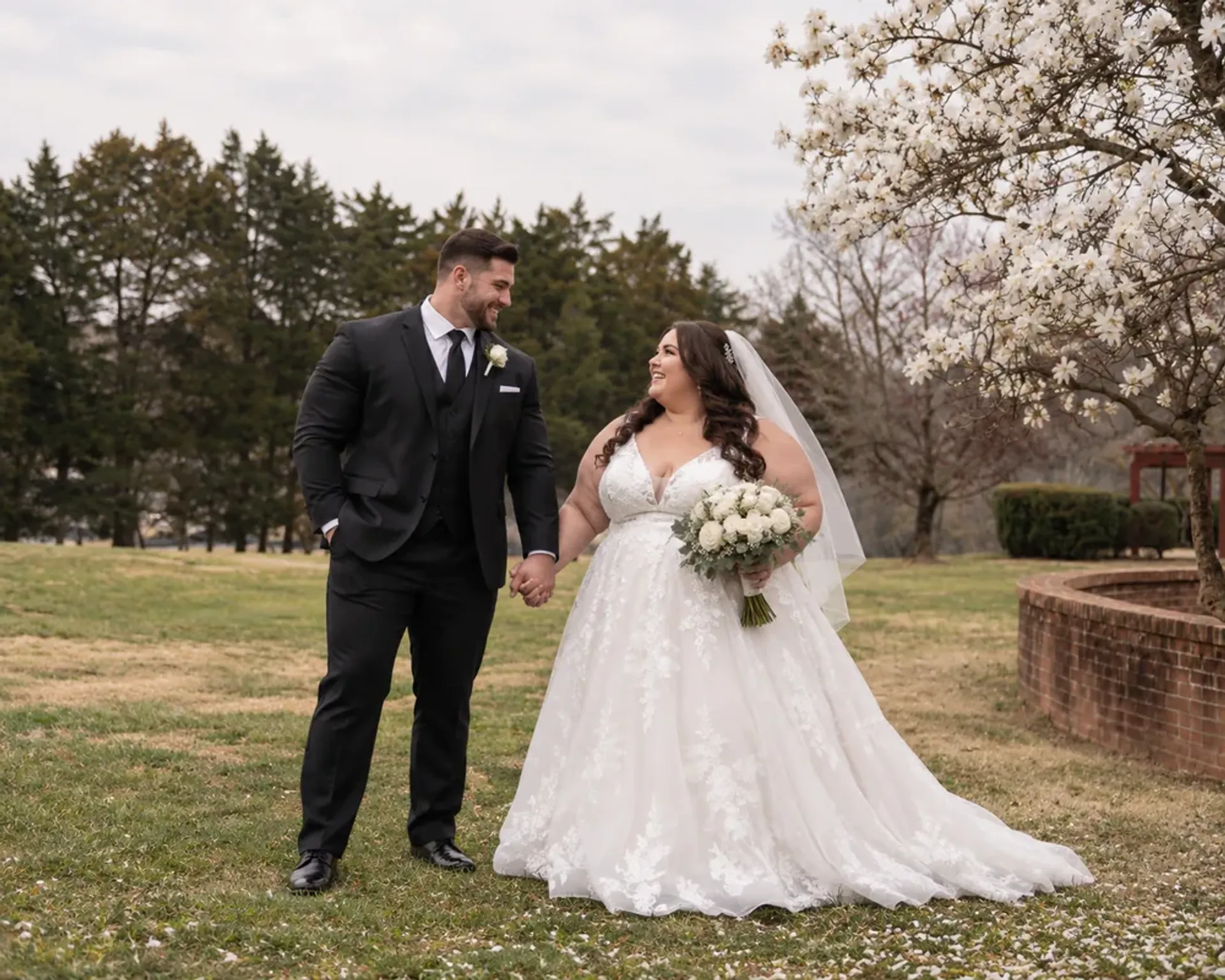Fit groom holding hands with a curvy bride on their wedding day