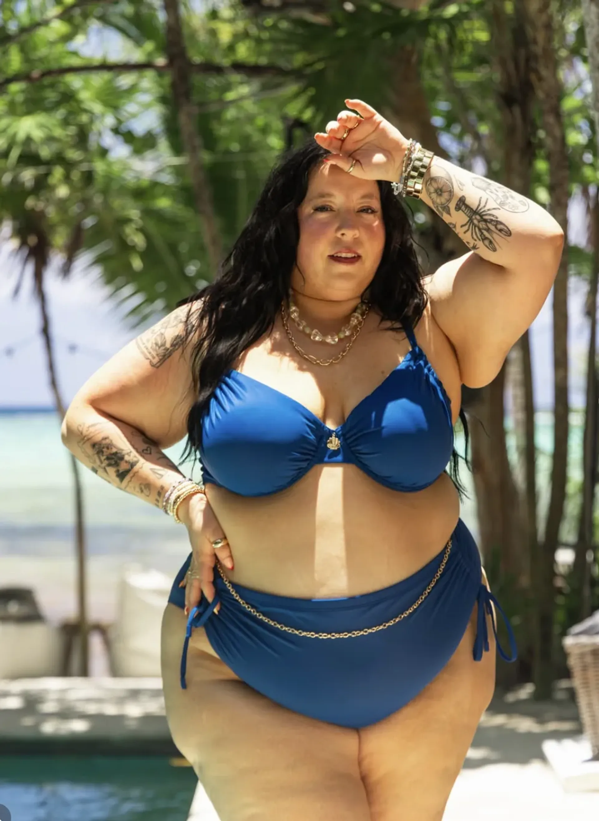 Alicia Mccarvell wearing a blue bikini in a tropical setting