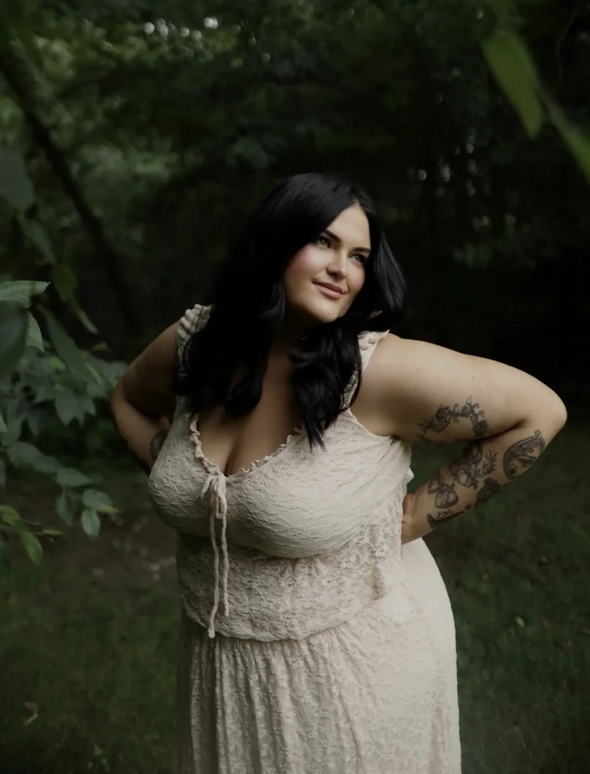 Gabriella Athena Halikas posing in a white lace dress outdoors